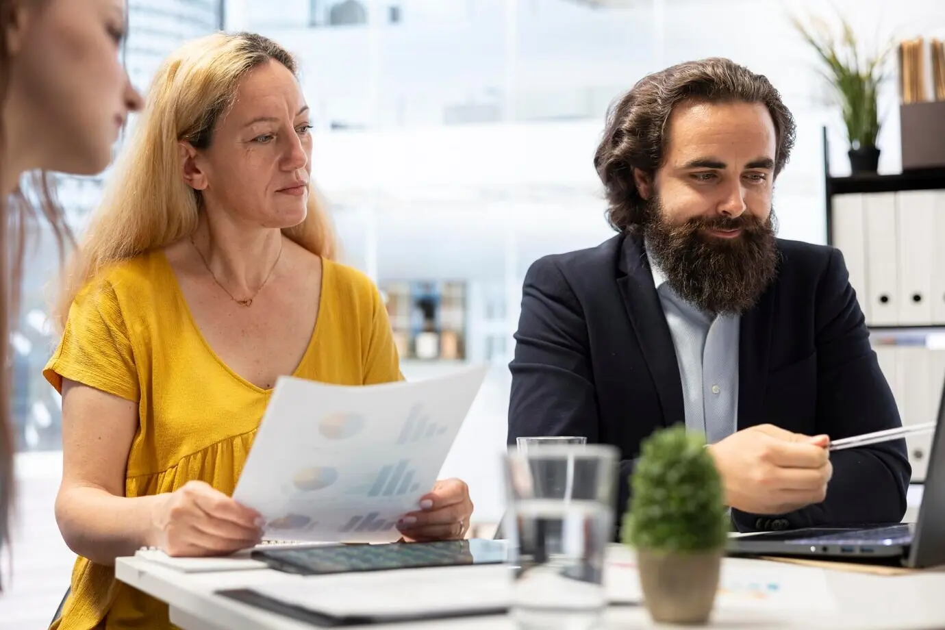 Conseiller financier souriant établissant un fonds d’urgence pour des clients à l’aide d’un ordinateur portable.