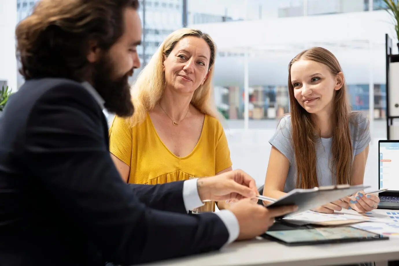 Dans un bureau, un agent présente à une famille l'évolution économique d'un portefeuille.